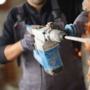 Close,Up,Of,A,Construction,Worker,Using,Rotary,Hammer,To